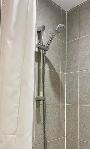 a shower with a shower head in a bathroom at 1 Bed Apartment By Cozy Quarters Property Management Short Term Lets Hartlepool Near Beach in Hartlepool