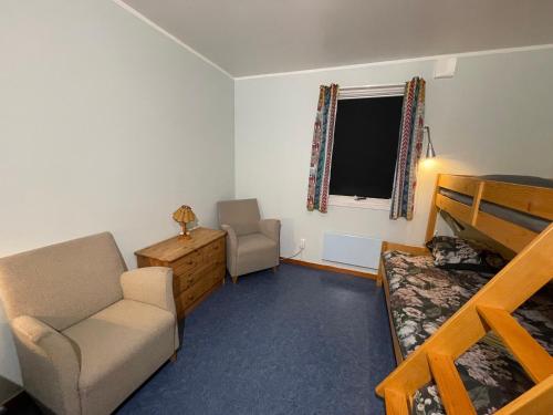 a bedroom with a bunk bed and a couch and a chair at Laplanders room 4 in Kiruna