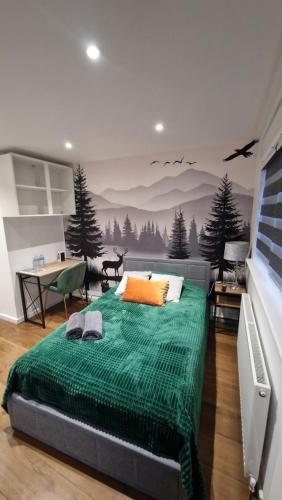 a bedroom with a bed with a green blanket at Private Studio Suite, 24h Self Check-in in Luton