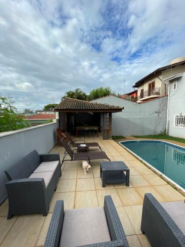 a patio with furniture and a swimming pool at Casa para alugar 3 suítes e um Quarto in Campinas