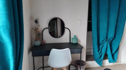 une table noire avec un miroir et une chaise blanche dans l'établissement Mon Refuge B&B, à Jougne