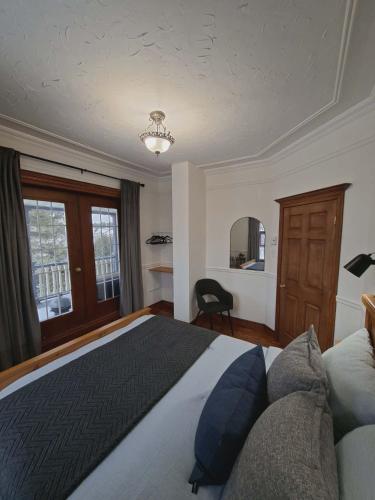 a bedroom with a bed and a chair and a window at Cabines Boréales et Maison de chambres in Rimouski