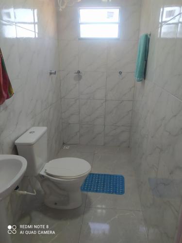a white bathroom with a toilet and a shower at PÔR Do SOL BEACH in Marataizes