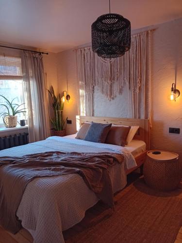 a bedroom with a large bed and a window at BOHO Ogre in Ogre