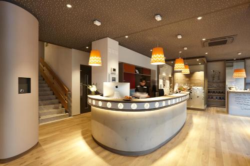 a lobby with a counter with a person in the background at Steinenschanze Stadthotel in Basel