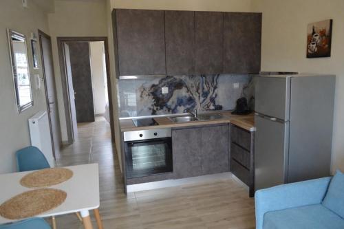 a kitchen with a stainless steel refrigerator and a table at GoCity apartments in Volos