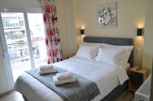 a bedroom with a bed with two towels on it at GoCity apartments in Volos
