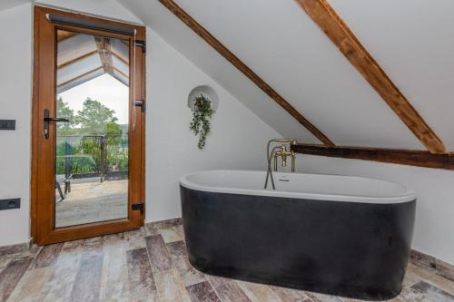 a large bath tub in a room with a window at Villa Nancy with jacuzzi in Benkovac