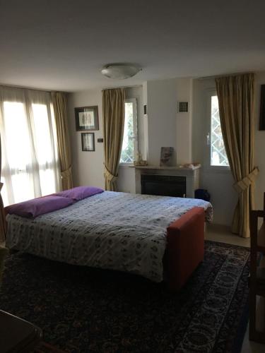 1 dormitorio con 1 cama con almohadas y ventanas moradas en Apartment Whenlifeisbetter, en Casal Palocco