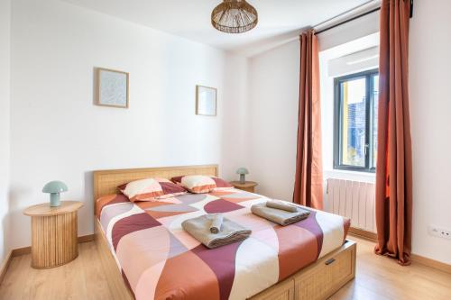 a bedroom with a bed with a colorful blanket and a window at Romantic getaway with jacuzzi, Garden view in Mulhouse