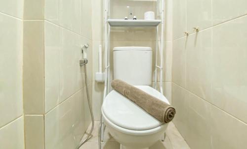 a white bathroom with a toilet and a sink at Osaka Riverview PIK2 By Micky Studio 3 in Rawalumpang