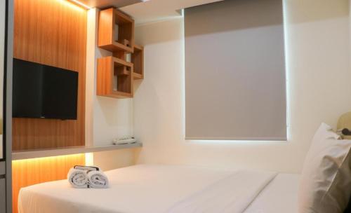 a bedroom with a bed with two towels on it at Osaka Riverview PIK2 By Micky Studio 3 in Rawalumpang