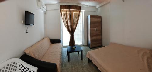 a small room with a bed and a couch and a window at vila matejevic in Star Dojran