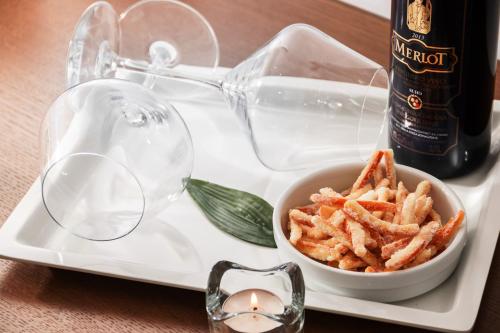 a tray with a bottle of wine and a bowl of french fries at Prima Luxury Rooms in Split