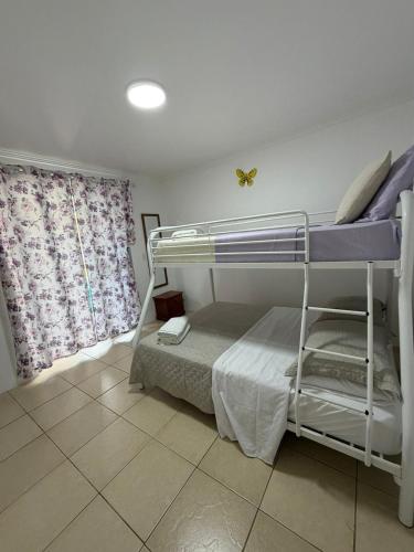 a bedroom with bunk beds and a butterfly on the wall at Cactus & Cove Villa in Santa Cruz