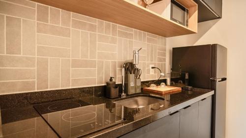 a kitchen with a sink and a refrigerator at Almagah 227 - Studios de Alto Padrão no Tatuapé - SP in São Paulo