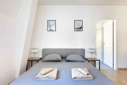 a bedroom with a bed with towels on it at Romantic getaway with Jacuzzi, Downtown in Mulhouse