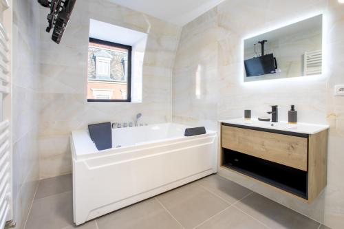 a white bathroom with a tub and a sink at Romantic getaway with Jacuzzi, Downtown in Mulhouse