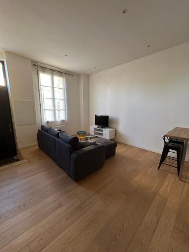 a living room with a couch and a table at Maison de ville in Libourne