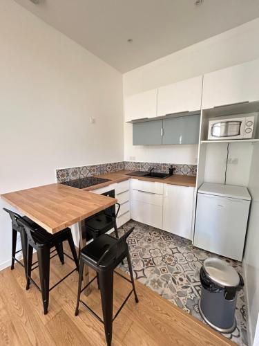 a kitchen with a wooden table and black chairs at Maison de ville in Libourne