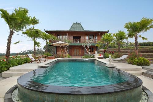 a house with a swimming pool in front of a house at Ti Amo Bali in Jatiluwih