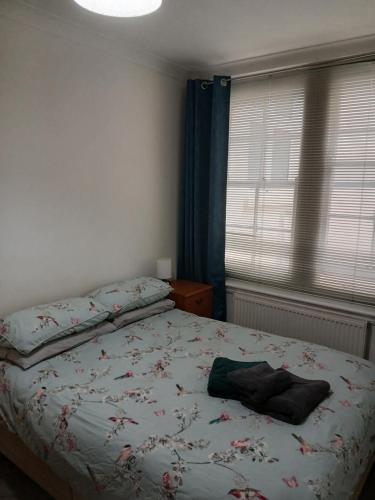 a bedroom with a bed with a flowery bedspread at Lovely 1-bedroom flat within minutes from the beach! in Bexhill