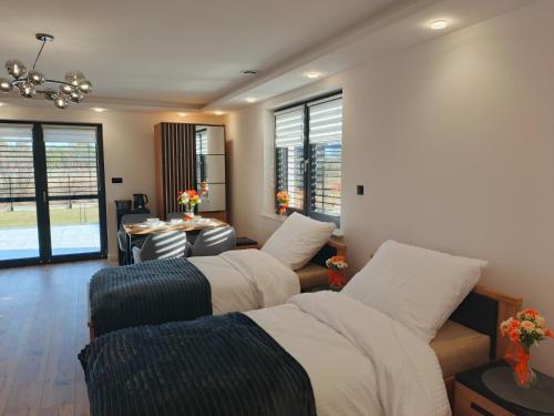 a room with two beds and a table and windows at Wakacyjna Pokusa in Kroczyce