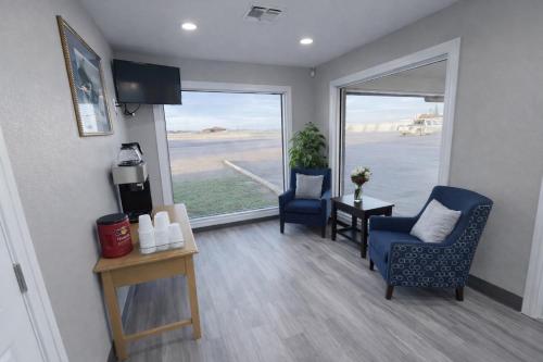 a living room with two chairs and a large window at Regency Inn Hondo in Hondo