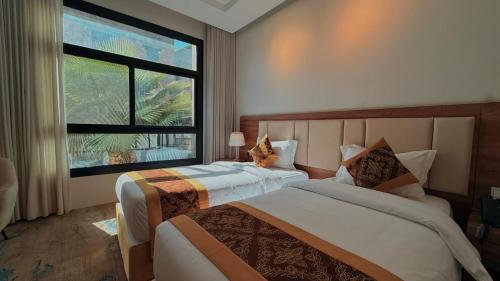 a bedroom with two beds and a large window at فندق نوفا ليس للخدمات الفندقيه in Najran