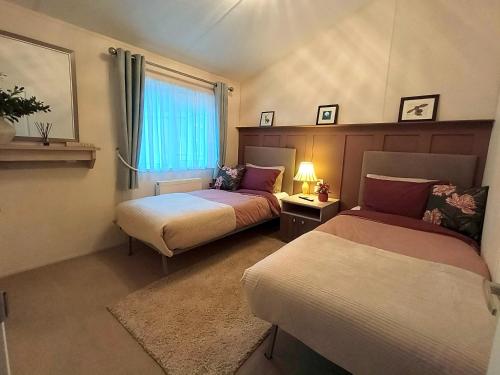 a room with two beds and a window at 10 lochview in Moffat