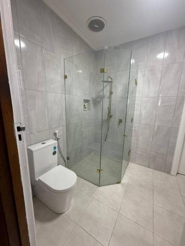 a bathroom with a toilet and a glass shower at Upper Esplanade Oceanview Escape in Bunbury