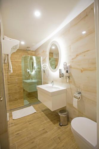 a bathroom with a sink and a toilet and a mirror at Aktug Elegance Hotel in Ordu
