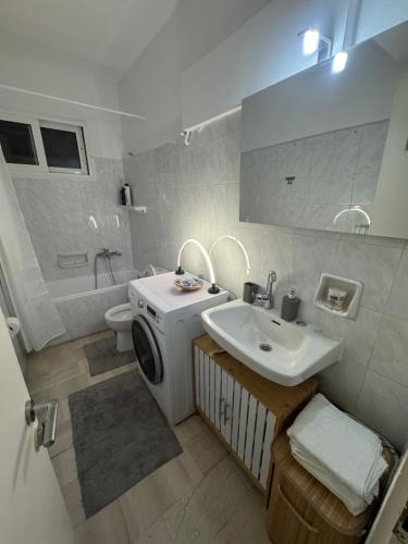 a bathroom with a sink and a washing machine at Dimitras Apartment with 3 bedrooms Elefsis in Eleusis