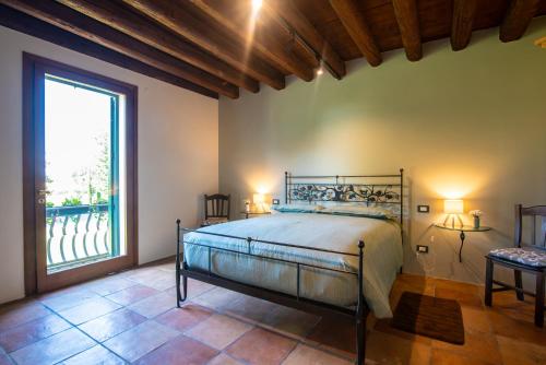 a bedroom with a bed and a large window at Il Salice Country Luxury in Due Carrare