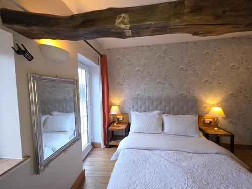 a bedroom with a large bed and a mirror at The Mews @ The Pheasant in Ironbridge