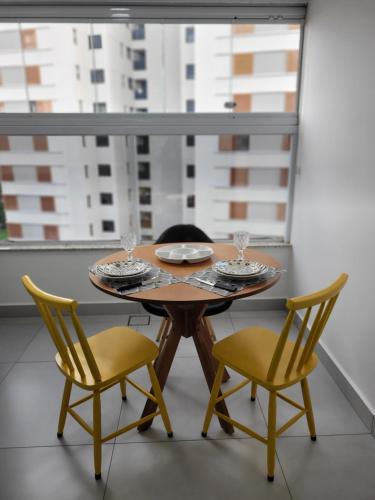 a table with two chairs and a table with glasses on it at Lavit 92 - Conforto, estilo e lazer com piscina e academia in Bauru
