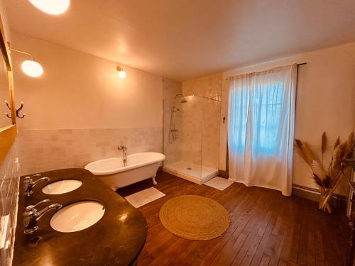a bathroom with a tub and a sink and a bath tub at Grande maison Albuconis in Saint-Oradoux-près-Crocq