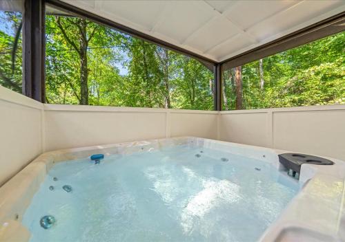 a hot tub in a room with a large window at Rustic Lodge - Pet-Friendly Cabin with Hot Tub & Fire Pit in Pigeon Forge