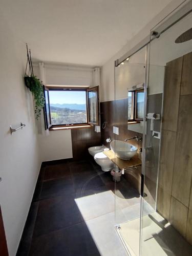 a bathroom with two toilets and a glass shower at B&B Bosco Ralle - comfort e natura in Satriano di Lucania