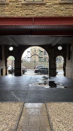 an entrance to a building with a gate and a parking lot at Cosy family apartment in Bradford