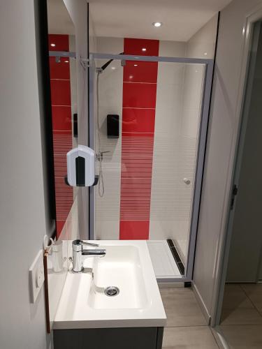 a bathroom with a white sink and a shower at Appartement original tout confort in Condamine