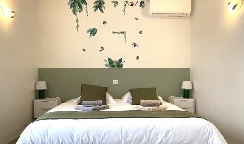 a bedroom with a bed with plants on the wall at Puravida Apparts in Lagnieu