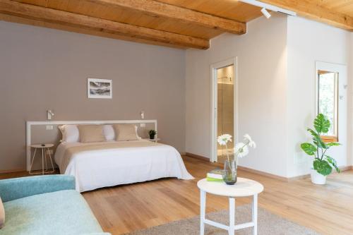 a white bedroom with a bed and a blue couch at Le Vie del Borgo | 3 dimore indipendenti a Civita in Civita