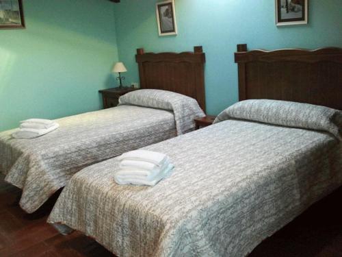 two beds in a hotel room with towels on them at Casa rural EL BOMBO in Tomelloso