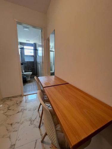 a dining room with a wooden table and chairs at Charlotte Beach Inn in Mangaratiba