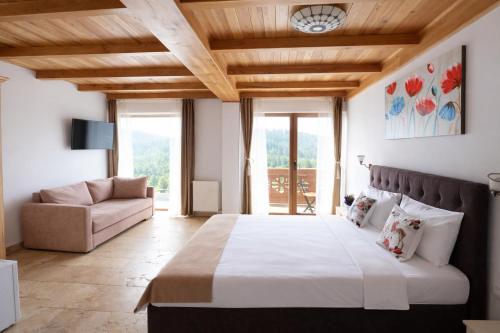 a bedroom with a large bed and a couch at Vila Belcin Spa&Retreat in Buşteni