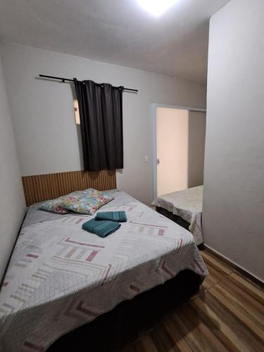a small bedroom with a bed and a window at Suite Nomar in Brotas