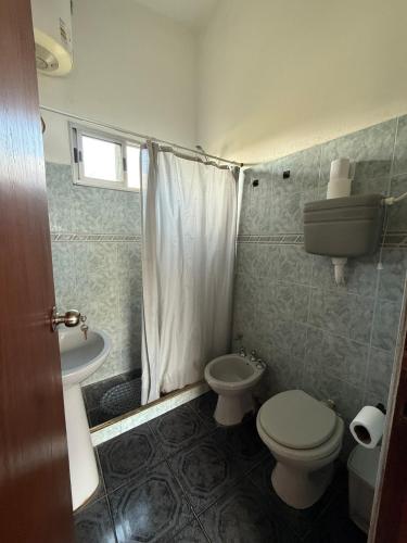a small bathroom with a toilet and a sink at House in La Tuna in Balneario Argentino