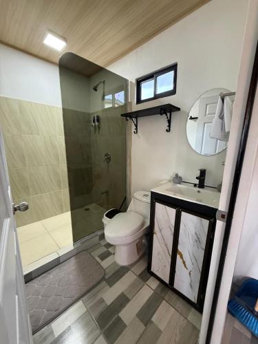 a bathroom with a toilet and a shower and a sink at Arenal cautiva in El Castillo de La Fortuna