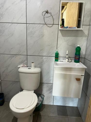 a bathroom with a toilet and a sink at Galpão, Pousada Paraíso do Arruda in Lages